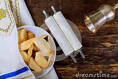 Hamantaschen cookies and masks on wood desk background. Purim holiday kippah tallit Stock Photo