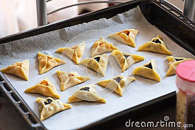 Hamantashen - traditional cookies for Purim, Jewish holiday. Triangular cookies on a baking sheet Stock Photo