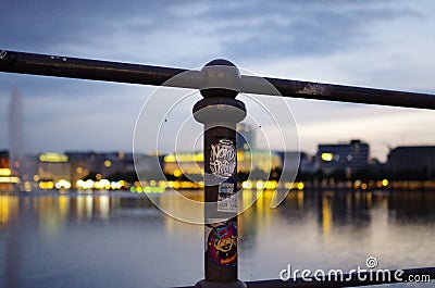 Hamburg Binnenalster at night with a railing and the department store `Alsterhaus` and fountain in the background, Picture was t Editorial Stock Photo