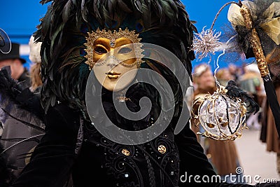 Hamburg, Germany, February 08, 2020: Golden mask with black feathers at the carnival celebration Maskenzauber, that means Magic Editorial Stock Photo