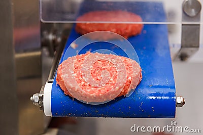 Hamburger meat on conveyor belt Stock Photo