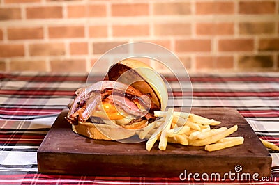 Hamburger sandwich with open brioche bread cream cheese fries bacon sauces on the table on blurred background Stock Photo