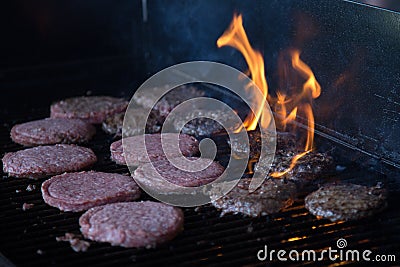 Hamburgers on Grill with Flames Stock Photo