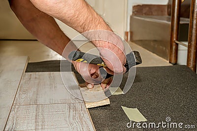 Hammer held by a person`s hand with amputated fingers as he works laying flooring in his home. Physical disability concept. Stock Photo