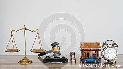 Hammer and scales with house and car, drench and clock on the table, white background Stock Photo