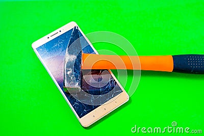 Hammer Smashing Smart Phone on green background Stock Photo