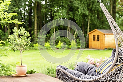 Hammock chair with striped cushion placed on terrace outside the Stock Photo