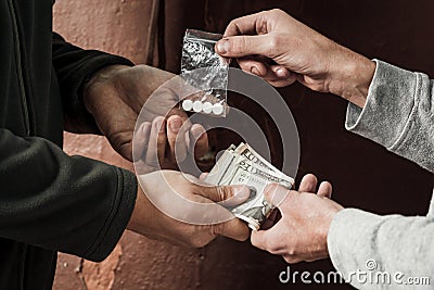 Hand of addict man with money buying dose of cocaine or heroine Stock Photo