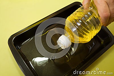Hand adds oil to pan Stock Photo