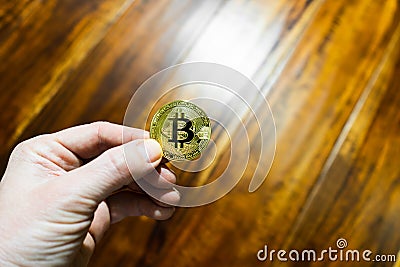Hand of an adult holds bitcoin coin. Stock Photo
