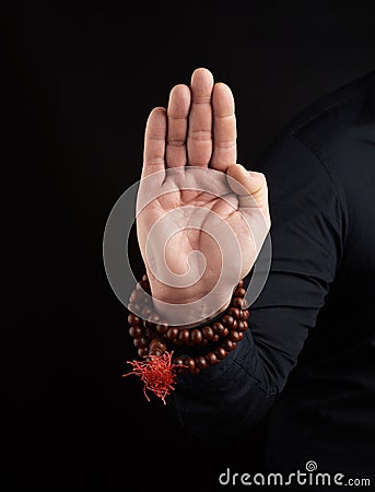 Hand of an adult male shows abhayaprada mudra on a dark background, protective gesture Stock Photo