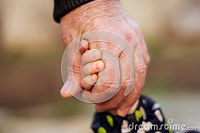 Hand of an adult man holding tightly child hand. Family connection, kid safety, protection and anti kidnap concept Stock Photo