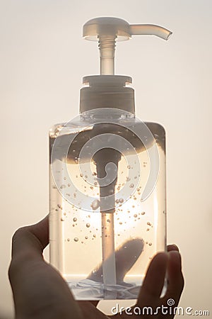 Hand with antibacterial transparent hand sanitizer gel in a plastic bottle Stock Photo