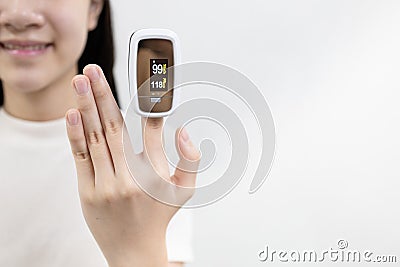 Hand of asian child girl with an attached pulse oximeter on fingertip,lady measuring heart rate,checking oxygen saturation level Stock Photo