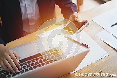 Hand of asian woman business hold smart mobile phone and using laptop in business group,small business cooperation work in working Stock Photo