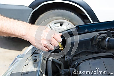 Hand of auto mechanic with a tool checking oil level Stock Photo