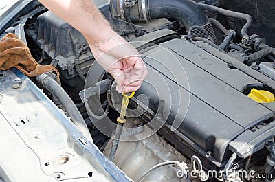 Hand of auto mechanic with a tool under car hood Stock Photo