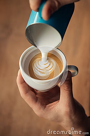 Hand of barista making latte or cappuccino closeup Stock Photo