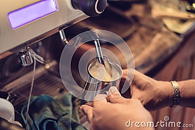 Hand barista steam milk in metal mug on coffee maker Stock Photo