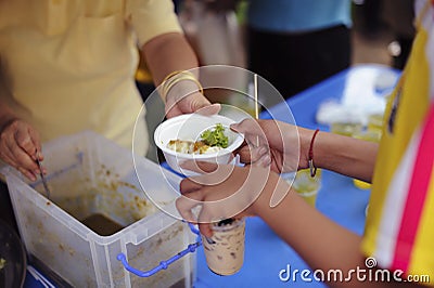 Hand begging for food from the rich`s share : The beggar is waiting for food from charity aid : the concept of begging and hunger Stock Photo