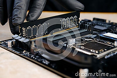 hand in black glove installing memory module in pc motherboard V3 Stock Photo