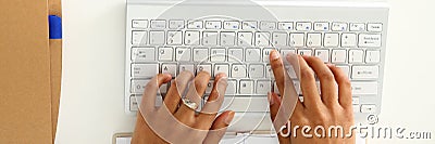 Hand of black woman type something with white wireless computer keyboard Stock Photo