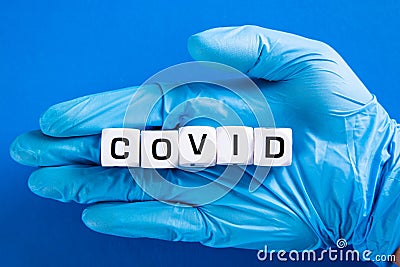 Hand in blue glove with Covid word. COVID-19 pandemic concept Stock Photo