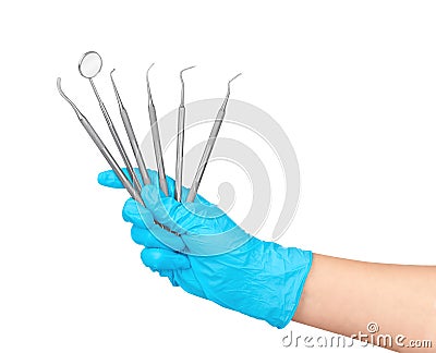 Hand in blue glove holds a lot of dental instruments Stock Photo