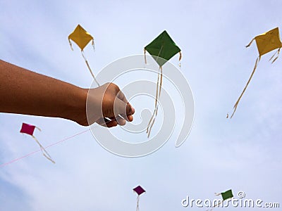 Hand of a boy raises a kite in a sky Stock Photo