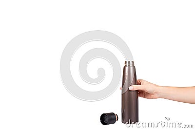 Hand with brown metal thermos, travel mug for hot drinks Stock Photo