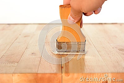 Hand with brush applying on wood table Stock Photo