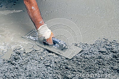 Hand builder with trowel leveling concrete 2 Stock Photo