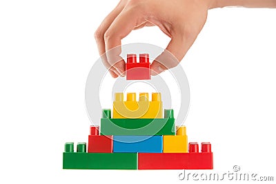 Hand building up a wall by stacking up lego, business conception Stock Photo