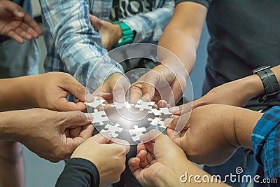 The hand of a business group who wants to put a piece of jigsaw. Stock Photo