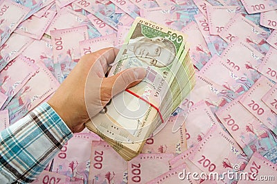 The hand of a business woman holds a bundle of hryvnias. Money background. Financial concept. Ukrainian banknotes. 500 and 200 hry Stock Photo