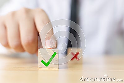 Hand of a businessman chooses checkmark and x sign symbol Stock Photo