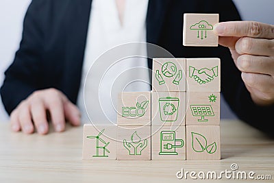 Hand of a businessman chooses reduce co2 icon on wood block circle.idea for environmentally conscious business, climate change, Stock Photo