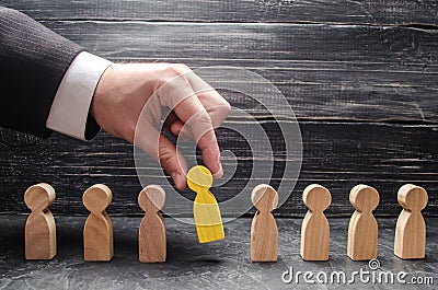 hand of a businessman takes a wooden figure of a man. Stock Photo