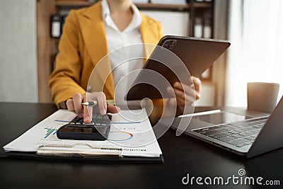Hand businesswoman doing finances and calculate on desk about cost at office Stock Photo