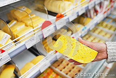 Hand of the buyer with a piece of cheese in the store Stock Photo