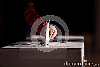 Hand casting a vote into the ballot box Stock Photo