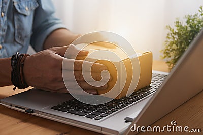 Hand of Casual Businessman Catch Parcel or Box on Laptop Stock Photo