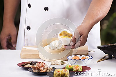 Hand of chefd holding steamed dumpling bun Stock Photo