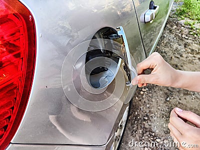 Hand of child Opening the fuel tank lid. Downloading, stealing gasoline from a car. Prank, pampering, wrecking Stock Photo
