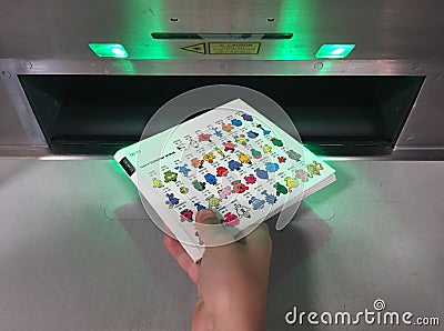 Hand of a child returning a book into an automated book return machine Editorial Stock Photo