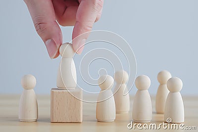 Hand Choose figure standing out from the group of crowd. Choice of employee leader from the crowd. Stock Photo