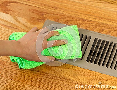 Hand Cleaning Grill Plate of Floor Heating Vent in Home Stock Photo