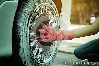 Hand cleaning tire car wash with sponge Stock Photo