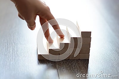 Hand climbing stairs made by wooden blocks Stock Photo