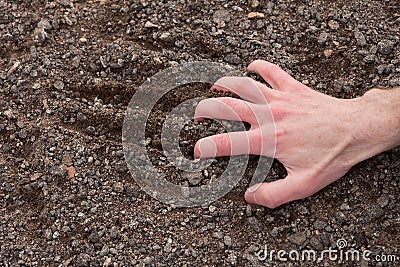 Hand clinging to a stony ground Stock Photo
